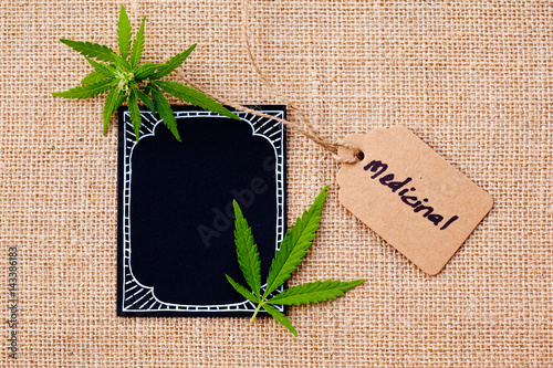 Marijuana - Cannabis - Medicinal with blackboard and tag on burlap hessian background 