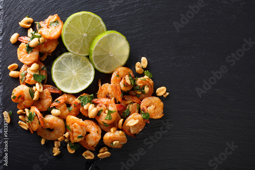 Spicy sauteed of shrimp, peanuts, lime and herbs closeup. horizontal top view