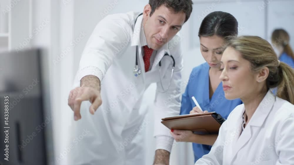  Medical team in modern hospital looking at computer & having a meeting