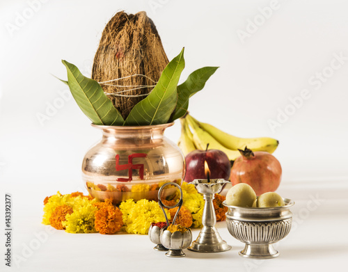 copper kalash with coconut and mango leaf with floral decoration, fruits, diya, sweet pedha,essential in hindu puja, front view, closeup