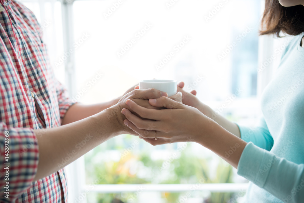 Peaceful asian young couple relaxing at home with cup of tea