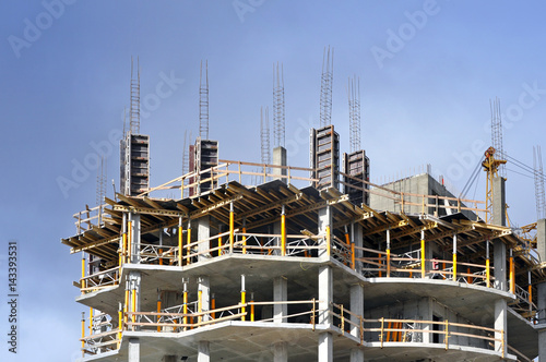 The process of construction of multistory monolithic building. Concrete and metal frame of floor slabs and columns.
