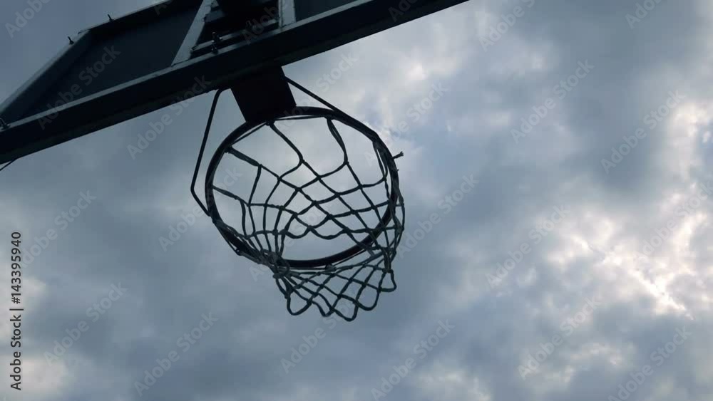 Ball going through basket hoop in backyard amateur basketball court, handheld camera Ball going through basket hoop in backyard amateur basketball court, handheld camera