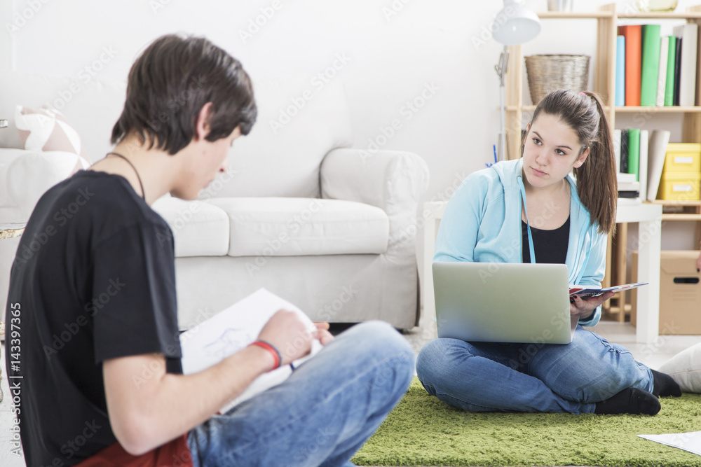 Two teenage friend studying on the floor Two teenage friend studying on the floor