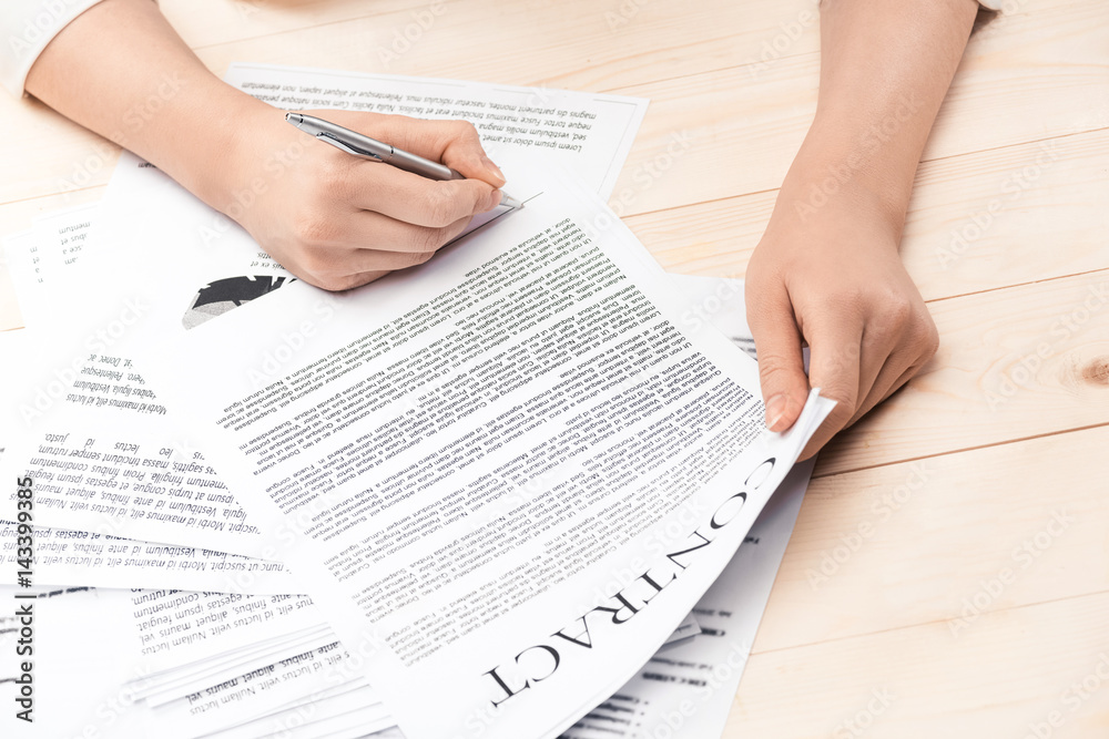 Obraz premium cropped view of businesswoman signing contract documents sitting at table