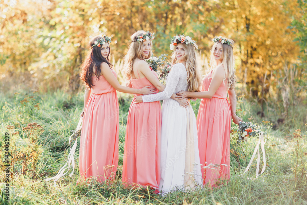 Beautiful bridesmaids in matching dresses. The bride and bridesmaids hugging.