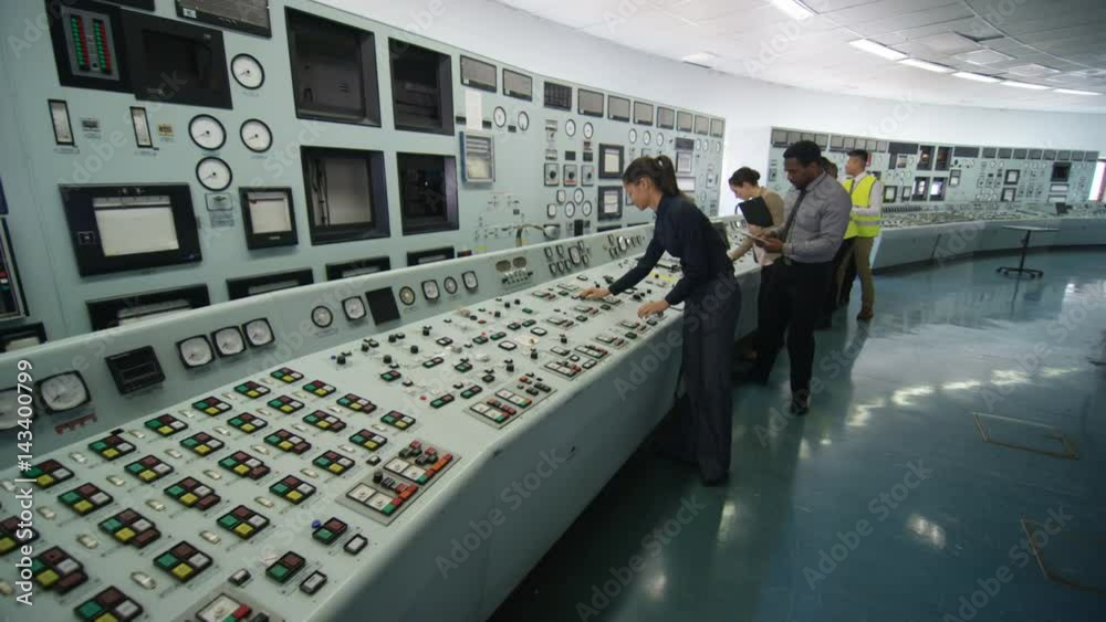  Mixed ethnicity team of engineers working in power station control room