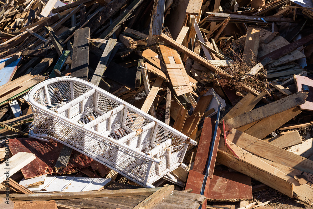 Trashed white rattan shelf in a pile of sorted wooden debris. Trashed white rattan shelf in a pile of sorted wooden debris.