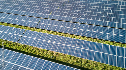 Solar Farm and panels. Rows of solar panels creating an abstract full-frame background texture of blue and green on a bright sunny day.