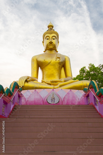 Big Golden Buddha statue over scenic white and blue sky  at Wat Sai Dong Yang Temple. Phichit, Thailand. photo