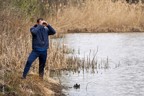 Man watching birds by the lake