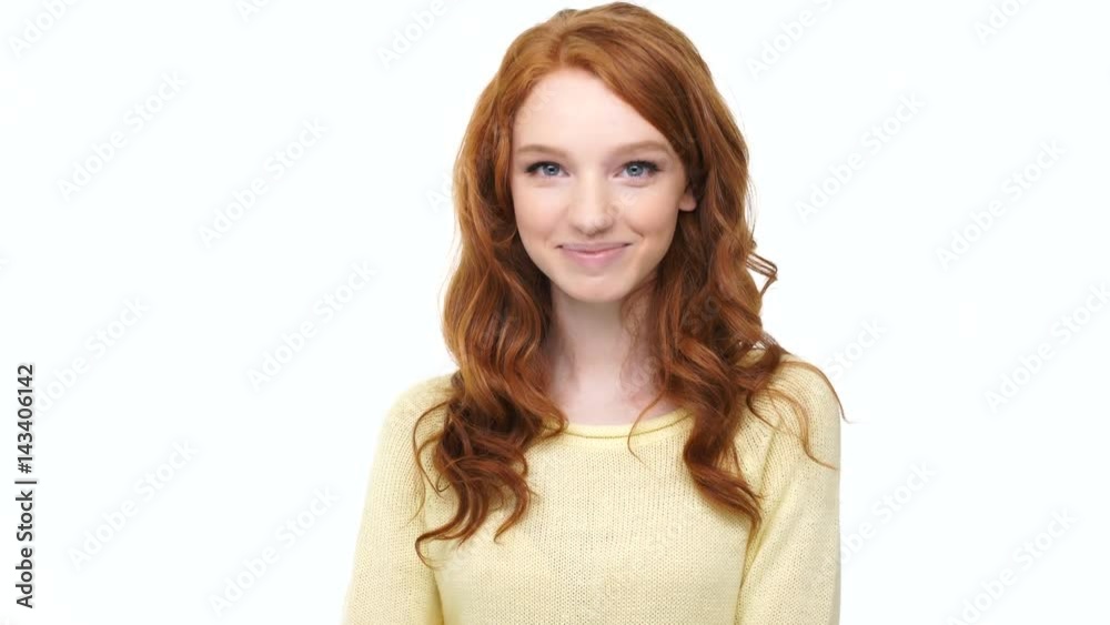 Happy young smiling woman with red curly hair waving her hand as greeting over white Happy young smiling woman with red curly hair waving her hand as greeting over white