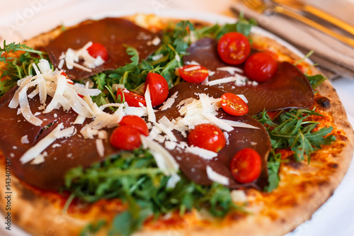 Pizza mit Bresaola und frischen Tomaten und Parmesan aus Italien