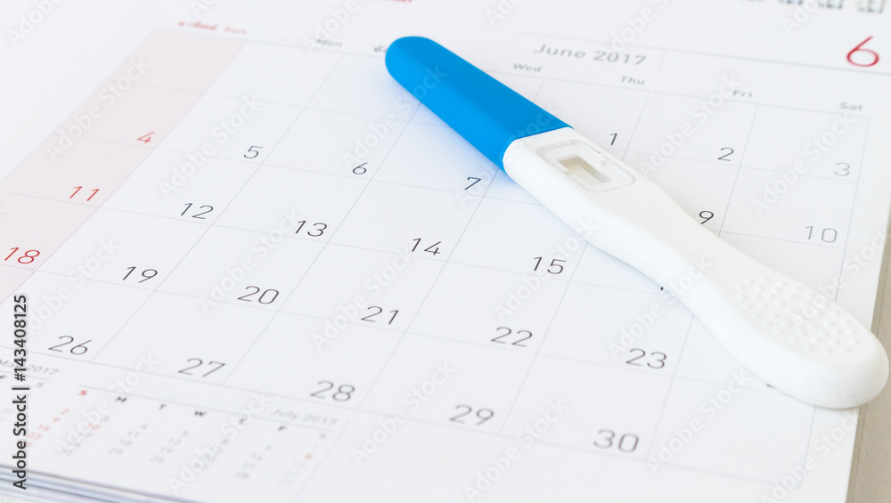 Pregnancy test on calendar background, health care concept Pregnancy test on calendar background, health care concept