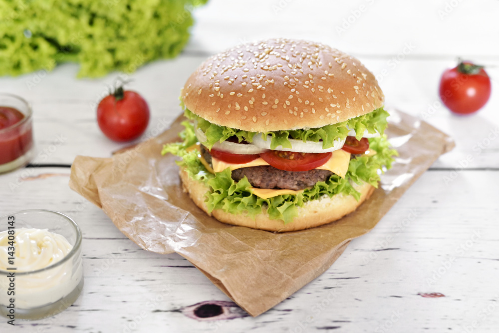 Fresh, delicious burger or cheeseburger with sauces and fresh ingredients. Hamburger on a white table. Fresh, delicious burger or cheeseburger with sauces and fresh ingredients. Hamburger on a white table.