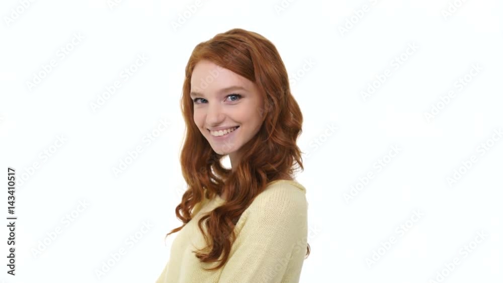 Smiling pretty girl with long red curly hair winking and flirting with camera isolated over white Smiling pretty girl with long red curly hair winking and flirting with camera isolated over white