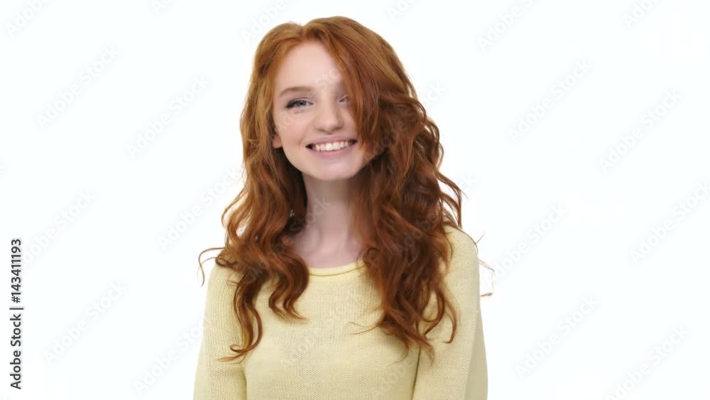 Happy pretty smiling girl playing with her red curly hair isolated over white Happy pretty smiling girl playing with her red curly hair isolated over white