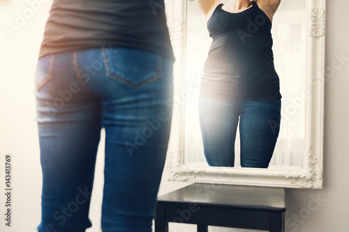 Obraz na płótnie anorexia concept - woman looks at her fat reflection in mirror