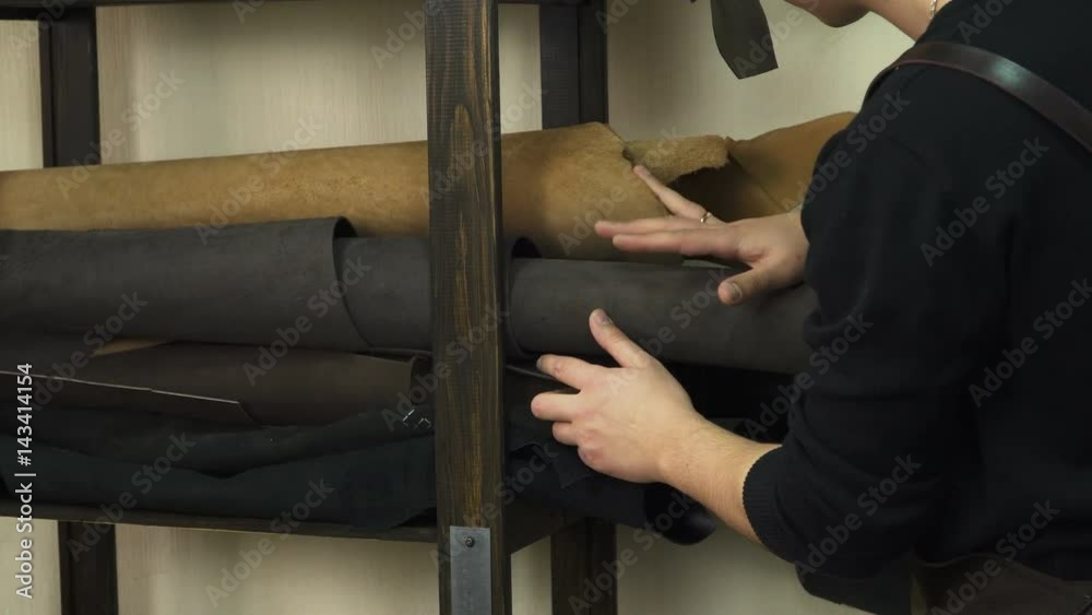 Craftsman inspecting and selecting the leather of the desired color. Making a leather product.
Craftsman inspecting and selecting the leather of the desired color. Making a leather product.
