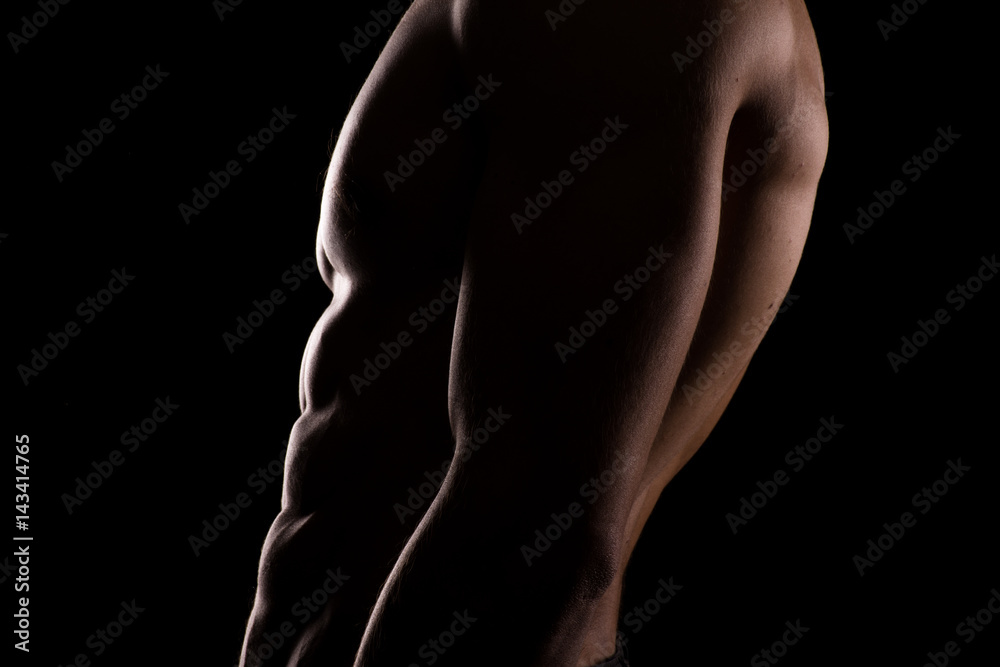 Close up of a sports man's chest. Muscular man on a dark background Close up of a sports man's chest. Muscular man on a dark background
