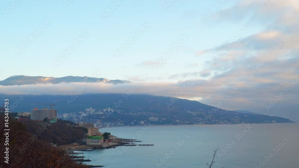 Sea Bay in the early morning. We see the coastal city and the mountains in the clouds. Yalta Crimea Sea Bay in the early morning. We see the coastal city and the mountains in the clouds. Yalta Crimea