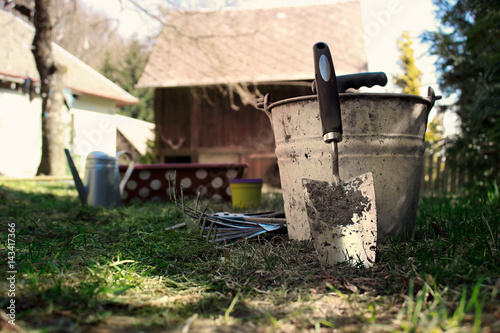 Gardening Tools on House Yard with Wooden Barn in Background