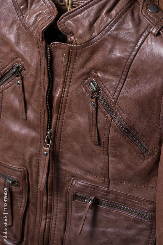Brown textured leather jacket. Leather jacket macro details. Jacket zippers and pockets. Brown textured leather jacket. Leather jacket macro details. Jacket zippers and pockets.