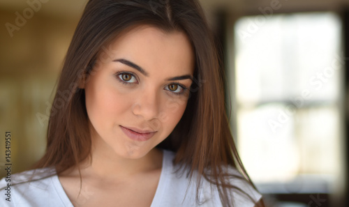 portrait of a brown-eyed brunette by the window