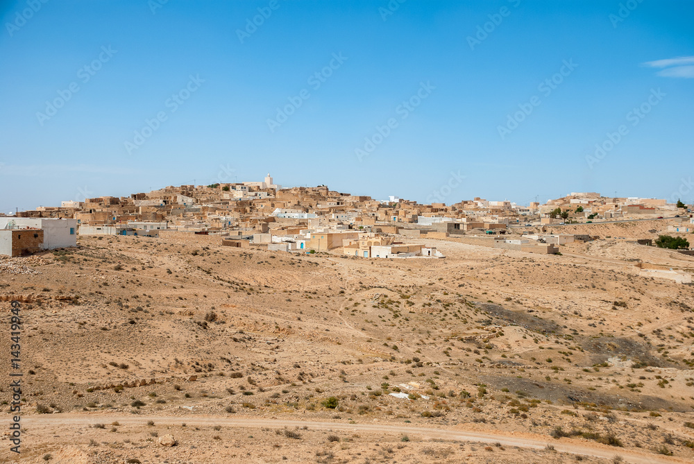 Traditional Arabian city on sand dunes in the desert