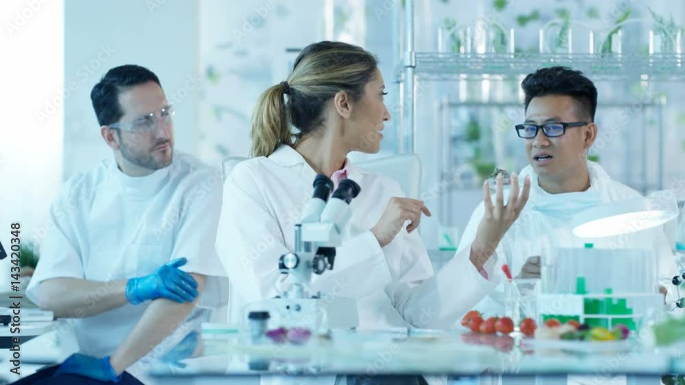 Research scientists analyzing foods in laboratory & discussing work Research scientists analyzing foods in laboratory & discussing work