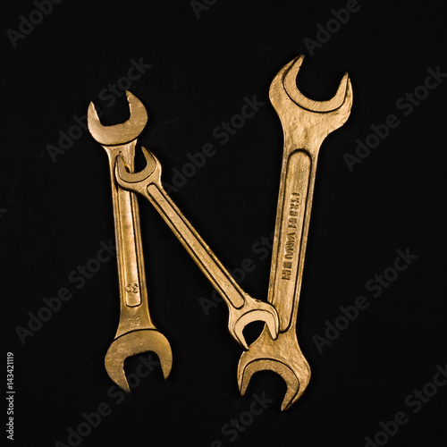 Letter N. Alphabet made of golden repair tools