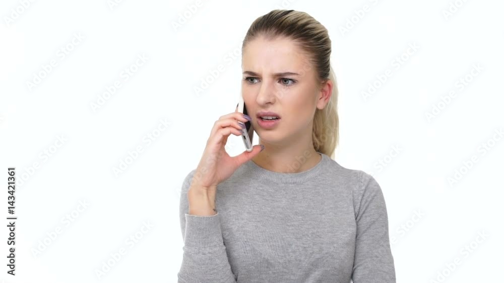 Angry young woman screaming while talking on mobile phone isolated on white background Angry young woman screaming while talking on mobile phone isolated on white background