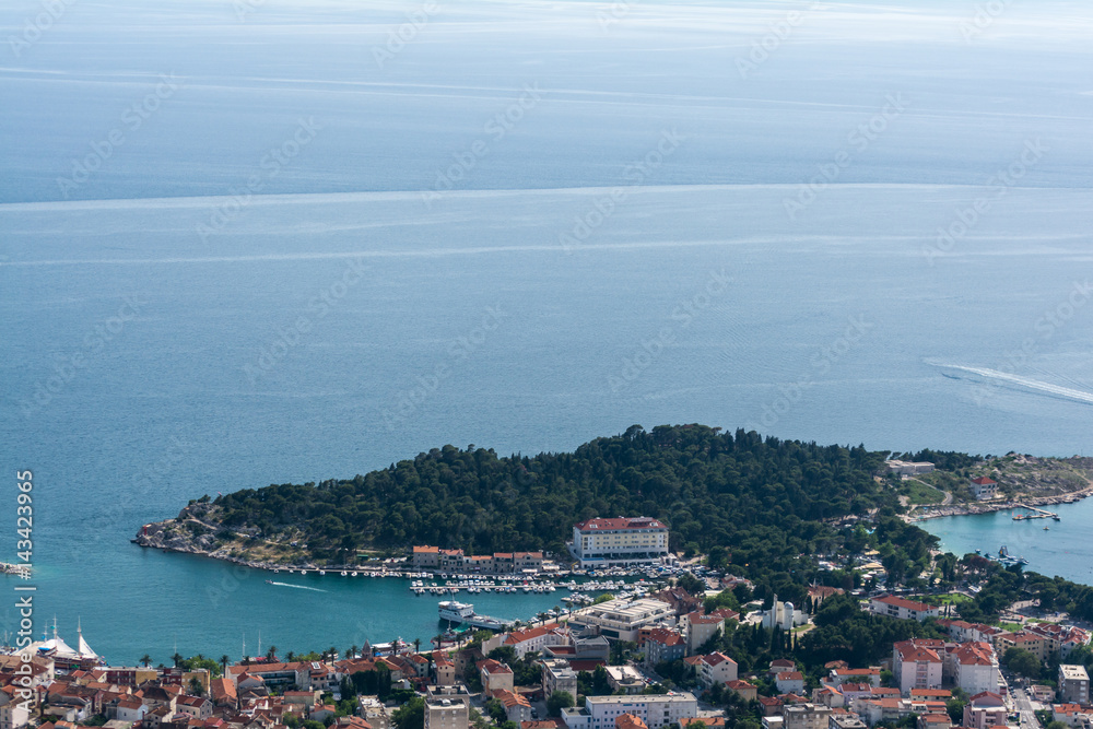 Above view from the mountain on famous croatian resort Makarska. Sea, bay, ships, beach and red roofs of well-known resort town birds view.
