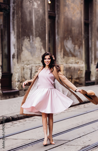 Woman whirls in her pink dress standing on the tramways
