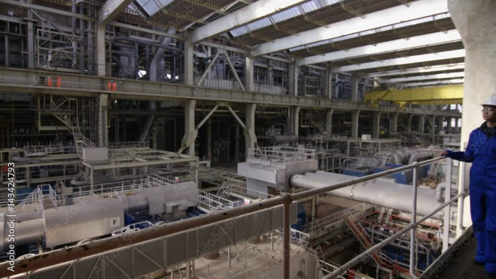 Interior view of huge industrial power plant & smiling female engineer Interior view of huge industrial power plant & smiling female engineer