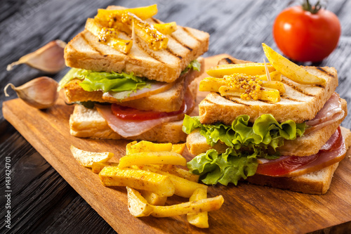 club sandwich with Tomato, lettuce, bacon, ham and french fries