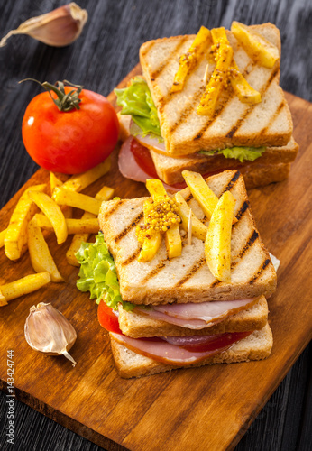 club sandwich with Tomato, lettuce, bacon, ham and french fries