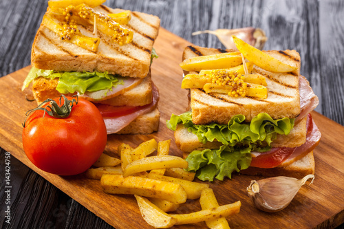 Canvastavla club sandwich with Tomato, lettuce, bacon, ham and french fries