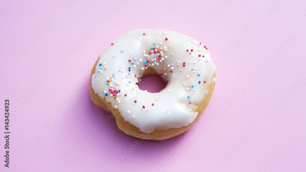 donut with colorful toppings on pink background