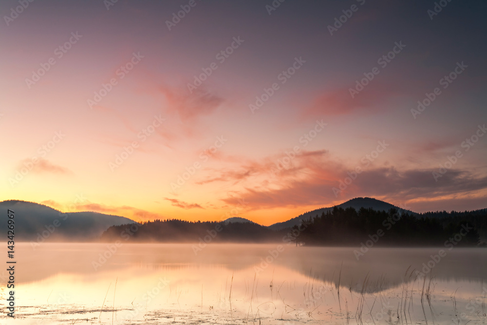 Red dawn by the misty lake