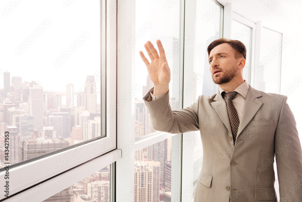 Fototapeta premium Concentrated serious businessman touching virtual screen