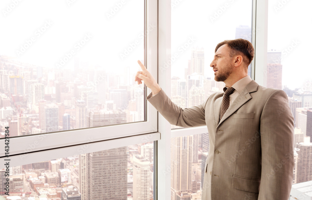 Serious businessman touching transparent screen Serious businessman touching transparent screen