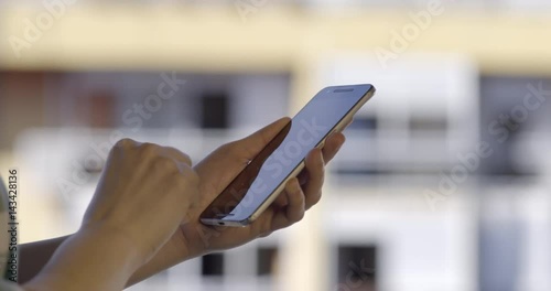 Woman sms texting using app on smart phone at day in city