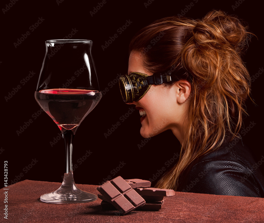 Red wine glass with chocolate and beautiful steampunk woman laughing Red wine glass with chocolate and beautiful steampunk woman laughing