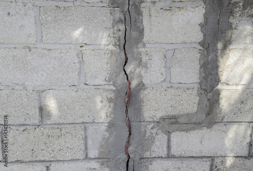 A crack in the concrete wall. The destruction of the wall from the gray blocks