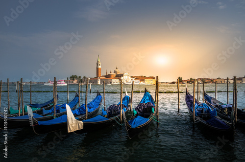 Pier for docking gondolas in Venice, Italy at sunset. In the background is Church of San Giorgio Maggiore. 