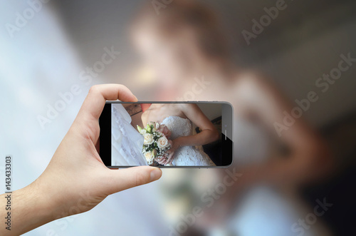 Taking picture of bouquet in bride hands with focus on flowers