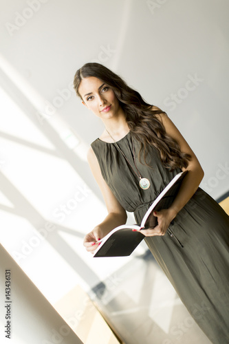 Pretty young woman in the room with book photo