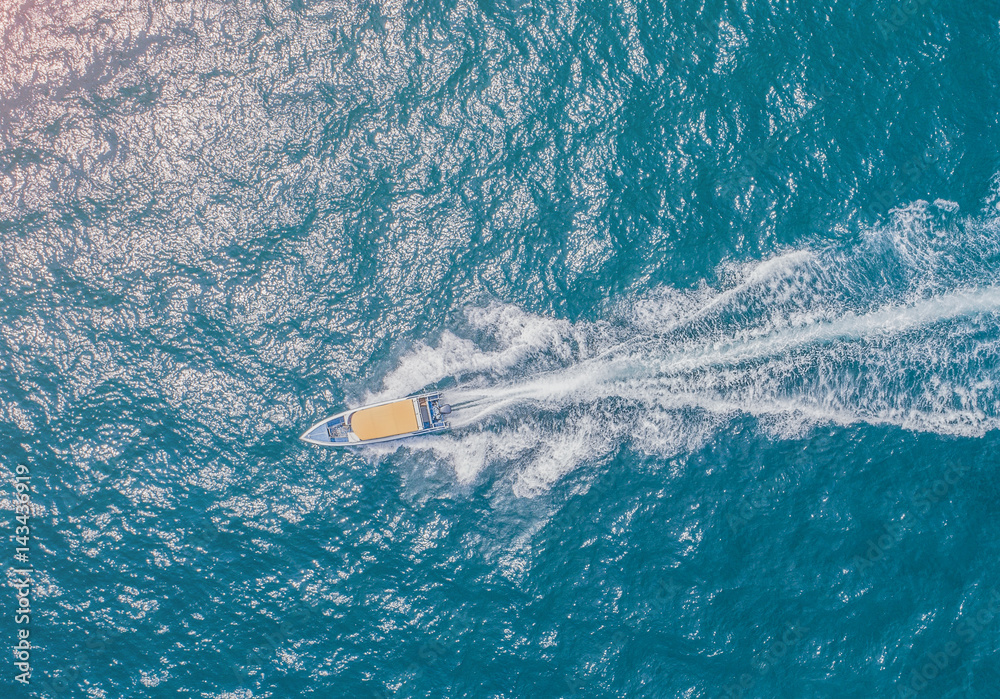 Obraz premium speed boat running fast in the sea coast in aerial view