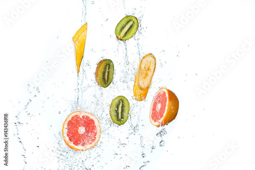 Fototapeta Naklejka Na Ścianę i Meble -  Fresh fruits falling in water splash, isolated on white background